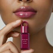 Model wearing glossy plum lip tint and holding RELUME Juicy Lip Tint