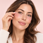 Woman applying a pink RELUME under-eye mask